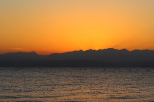 Солнечные лучи восходящего солнца над Красным морем из-за гор Иордании