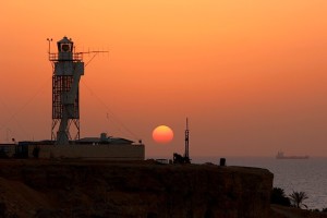 Восход солнца на фоне маяка и корабля в Красном море